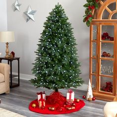 a living room with a christmas tree in the corner and presents on the floor next to it