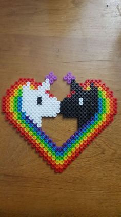 a couple of bears that are in the shape of a heart with a rainbow on it