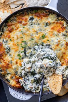 spinach dip in a skillet with tortilla chips and pita bread