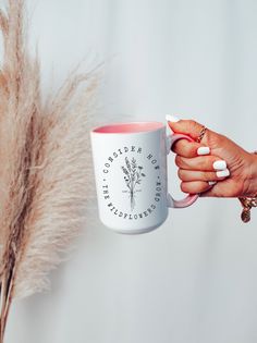 a woman holding a coffee mug in her hand