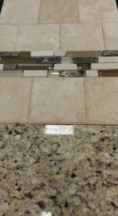 an image of a bathroom setting with marble and glass tiles on the wall, flooring