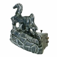 a silver horse statue sitting on top of a turtle like object with a white background