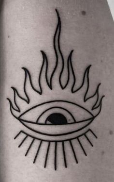 a black and white photo of an all seeing eye tattoo on the leg with flames coming out of it