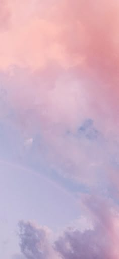 an airplane is flying in the sky with pink and blue clouds behind it on a sunny day