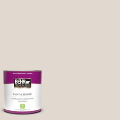 the behr paint and primer is shown in an open, beige - colored tin