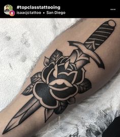 a black and white tattoo on the leg of a person with a knife in it