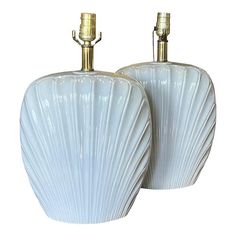 two white vases with gold accents are shown side by side on a white background