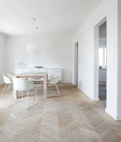 a dining room with white chairs and a wooden table