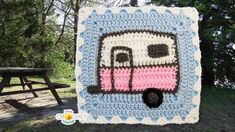 a crocheted blanket with a pink bus on it