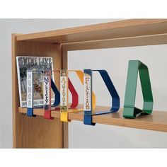 a book shelf with several books and magazines on it's sides, along with a pair of scissors