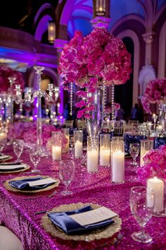 the table is set with pink flowers and candles for an elegant dinner or banquet event