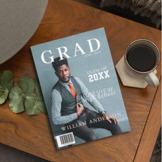 a magazine sitting on top of a wooden table next to a cup of coffee and a plant