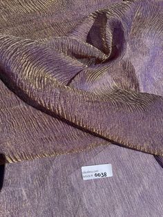 the fabric is purple and has a white tag on it that says, $ 0 00