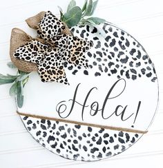 a leopard print plate with the word hola on it and a bow tied to it