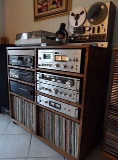 an old fashioned stereo system sitting on top of a wooden cabinet in front of a record player