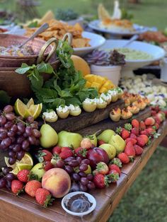 a wooden table topped with lots of different types of fruits and vegtables