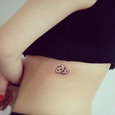 a woman's stomach with two cookies tattooed on it