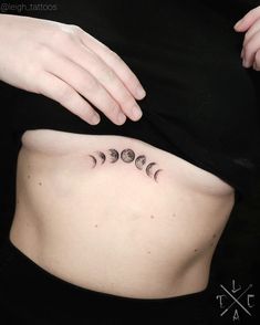 a woman's stomach with three phases of the moon tattooed on it