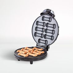 a waffle maker with several donuts in it's pancake tray on a white background