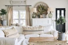 a living room filled with white furniture and lots of pillows on top of it's couches