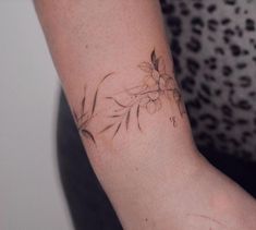 a woman's arm with a flower tattoo on the left side of her arm