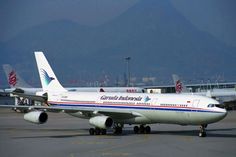 an airplane is sitting on the tarmac with mountains in the background