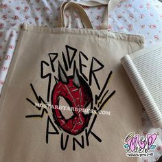 a tote bag with graffiti on it next to an open book