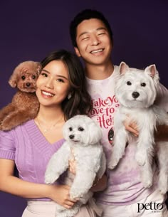 a man and woman holding two small dogs in front of a purple background with the words make love to her written on it