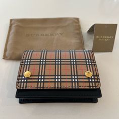 Burberry Preloved Wallet. Snap Closure. Good Condition. Jude Mini Vintage Check. Perfect Size For Smaller Bags! Dust Bag And Tag Included. Purchased From Shopthing In 2022. Shopthing Order/Receipt In Photos. Imperfections On Back Of Wallet Around Edges. Slight Discoloring Spot On Snaps On Front. See All Photos. Burberry Wallet, Small Bag, Spot On, Snap Closure, Burberry, Dust Bag, Bag Lady, Im Not Perfect, Size Small