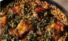 a skillet filled with meat and vegetables on top of a table