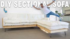 a man standing on top of a white couch in front of a wall with the words diy sectional sofa