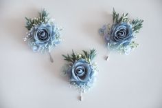 three blue flowers are placed on top of each other in the shape of boutions