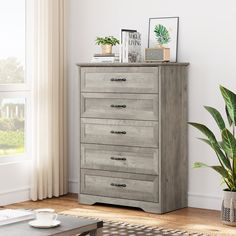 a wooden dresser sitting in a living room next to a window and potted plant