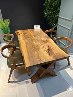 a wooden table sitting on top of a white tile floor next to two green chairs