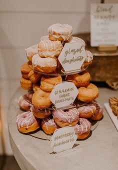 a stack of donuts sitting on top of a table next to other pastries