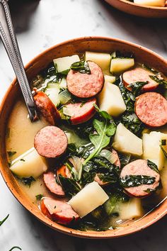 a bowl filled with sausage, potatoes and spinach next to another bowl full of soup