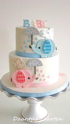 a three tiered cake with an elephant and bird decoration on it's top