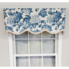 a blue and white flowered valance hanging on the side of a window