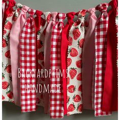 red and white gingham fabric with strawberrys on it, hanging from the wall