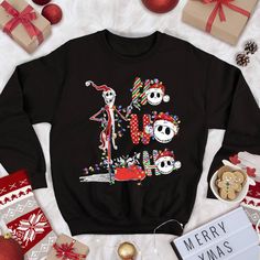 a black sweater with skeletons on it next to presents