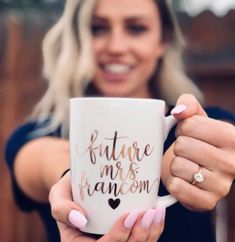 a woman holding a coffee mug with the words future mrs fanom written on it