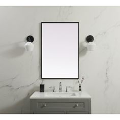 a bathroom vanity with a mirror above it and two lights on the wall next to it