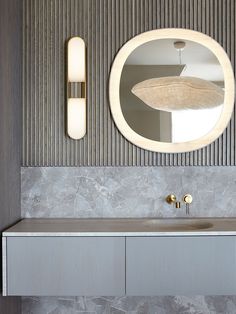 a bathroom with a sink, mirror and lights on the wall above it's counter