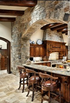 a large kitchen with an island in the middle and lots of stools around it