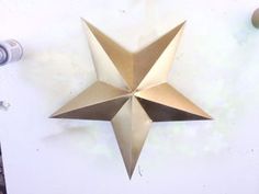 an origami star is hanging on the wall next to some knobs and a bottle opener