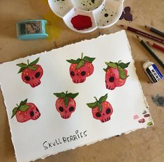 a painting with strawberries on it next to some paintbrushes and other art supplies