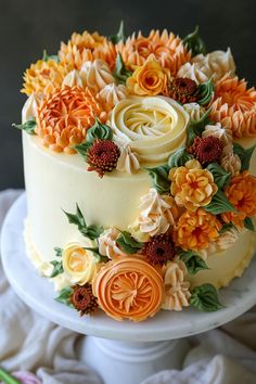 a white cake with orange and yellow flowers on it