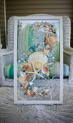 an image of seashells and starfish on the beach in front of a wicker chair