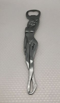 a bottle opener with the shape of a woman on it's face and legs