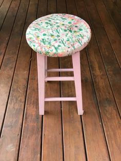 a pink stool with a cactus print seat cover on it's back and legs